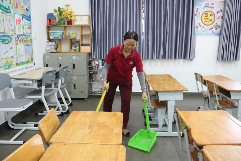 Cô Nguyễn Thị Lực – Nhân viên tạp vụ đang lau dọn lớp học trước khi học sinh đến trường